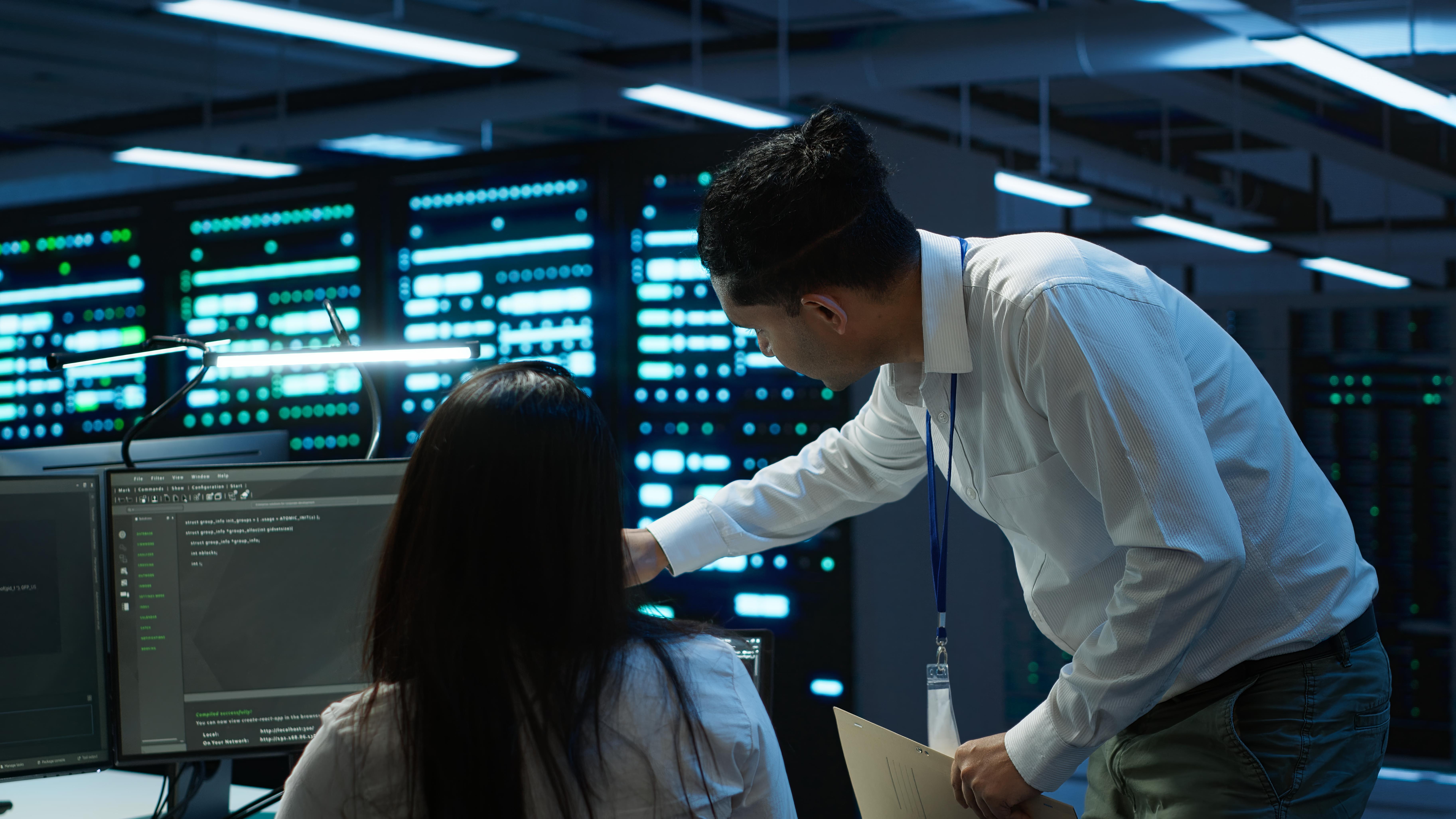 Server management professionals monitoring network infrastructure and performance in a modern data center environment
